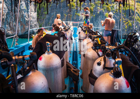 Subacquei ottenere pronto per immersioni su una barca piena di apparecchiature, Thailandia Foto Stock