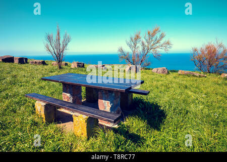 Posto di ristoro sulla montagna con una vista del mare. Tavolo in legno e due panche Foto Stock