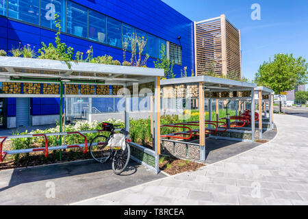 Queste bike shelters a IKEA sulla penisola di Greenwich hanno tetti verdi piantate con nettare ricco di piante e registri sovrapposti per creare bug alberghi. Foto Stock