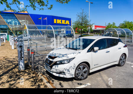 Una Nissan Leaf auto elettrica la carica a un Ecotricity punto di carica al di fuori del grande negozio IKEA sulla penisola di Greenwich. Foto Stock