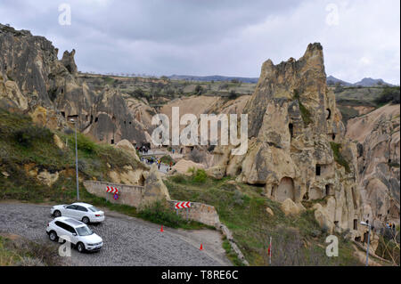 Vetture su strada tortuosa attraverso insolite formazioni geologiche in Cappadocia, Turchia Foto Stock