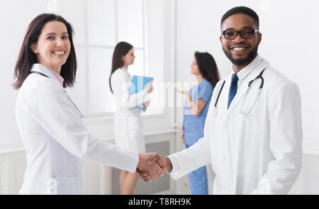 Benvenuto a bordo. Diversi medici stringono le mani Foto Stock
