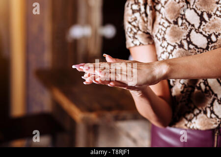 Close up foto di donna con le mani in mano l'applicazione di crema mani. Cura della pelle, la cura del corpo, prodotti di bellezza, spa, cura dei capelli concetto. Foto Stock