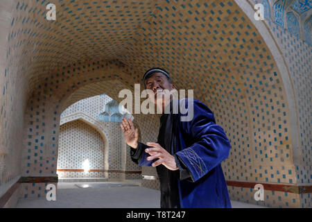 Un anziano uzbeko visita il mausoleo restaurato di Mazlum Khan SLU, noto anche come Mazlumkhon-Sulu, rivestito di piastrelle blu brillante risalenti al XIV secolo nella necropoli di Mizdakhan, antico cimitero, considerato uno dei più importanti siti zoroastriani dell'Asia centrale situato a sud della città di Khodjeyli nella Repubblica autonoma del Karakalpakstan all'interno dell'Uzbekistan Foto Stock