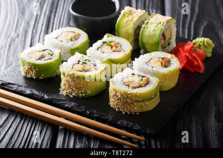Giapponese rotoli avvolti in avocado con frittata, di sesamo e di cetriolo closeup su una piastra sul tavolo orizzontale. Foto Stock