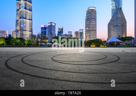 L'asfalto della pista e moderno skyline e edifici di Shanghai di notte Foto Stock
