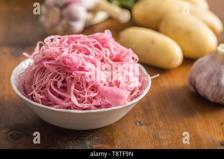 Cavolo acido con patate e aglio sul tavolo di legno Foto Stock