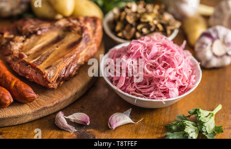 Cavolo acido funghi secchi affumicati costolette di maiale salsicce aglio patate e sedano erbe aromatiche Foto Stock