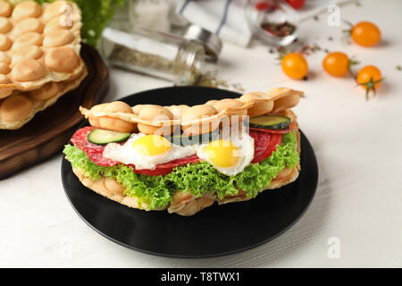 Bolla di deliziosi waffle con uova fritte su piastra Foto Stock