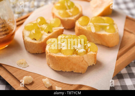 Gustosi panini con formaggio e Uva su pannello di legno Foto Stock