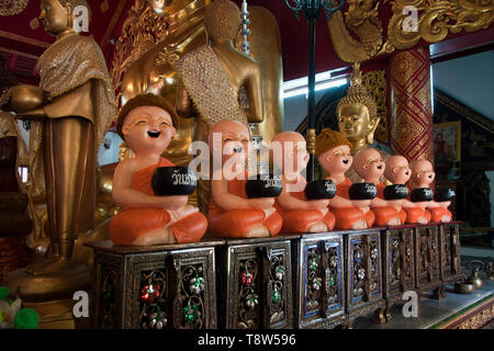 Chiang Rai Thailandia 4 Gen 2019, sette cherubino monaco statue ciascuna azienda un recipiente di contenimento etichettati per giorno della settimana per raccogliere le donazioni di Wat Klang Foto Stock