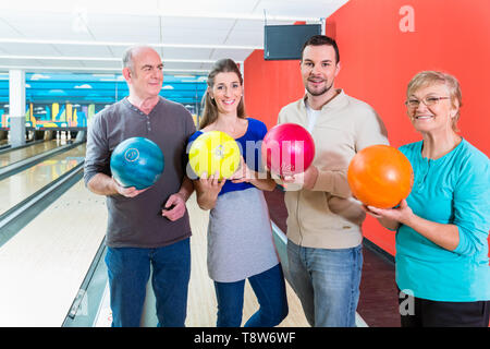 Sorridente azienda familiare multi colore palla da bowling Foto Stock