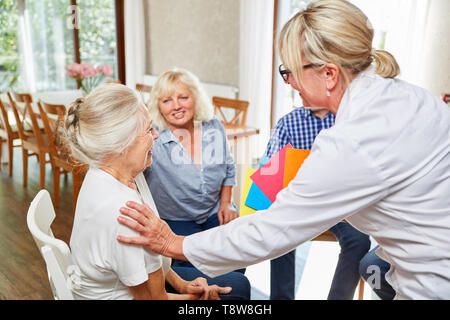 Psicoterapeuta guarda dopo gli anziani in una terapia di gruppo a sessione Foto Stock