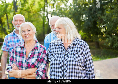 Gruppo di anziani come i pensionati e gli amici in una passeggiata nella natura Foto Stock