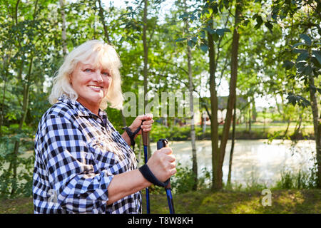 Vitale donna senior con treni in sovrappeso endurance di Nordic Walking Foto Stock