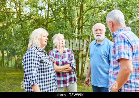 Senior group avente una conversazione su una natura viaggio Foto Stock