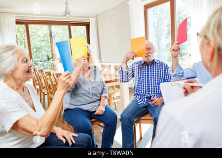 Gli anziani in occasione della riunione di un gruppo di terapia con uno psicoterapeuta nella casa di cura Foto Stock