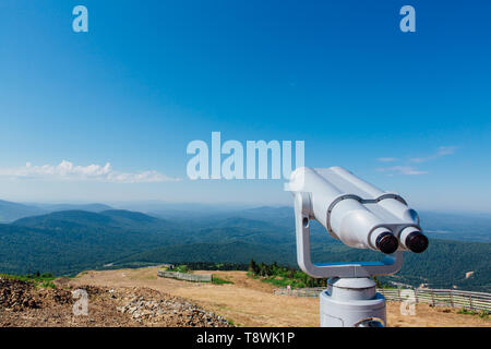 A gettone binocolo elettronico per i turisti su una montagna paesaggio estivo Foto Stock