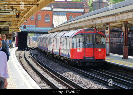 La Metropolitana arriva alla fermata della metropolitana di Hammersmith, London, Regno Unito Foto Stock