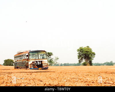 Abbandonato il vecchio bus in un campo vuoto della vecchia scuola bus in campo con alberi nessuno sfondo vintage Foto Stock