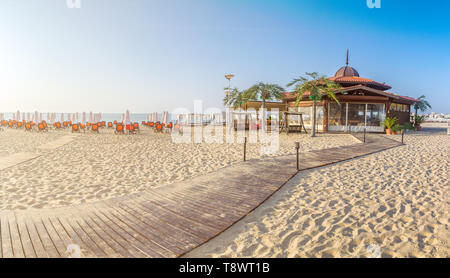 Un bar in spiaggia con sedie a sdraio e ombrelloni su una bellissima spiaggia a sunrise in Sunny Beach sulla costa del Mar Nero della Bulgaria. Vista panoramica. Foto Stock