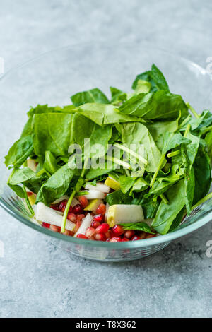 Pomegeranate e Insalata di pere nella ciotola di vetro pronto a fare. Alimenti biologici. Foto Stock