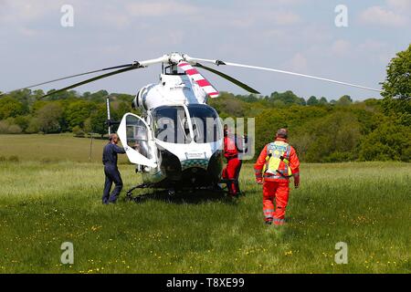 Tenterden, Kent, Regno Unito. 15 Maggio, 2019. Un Kent Surrey Sussex Air Ambulance è stato spedito a un incidente in centro città. Il personale medico sono a scena. L'emergenza ha avuto luogo presso il vecchio caseificio fabbrica di birra appena fuori la high street nel centro della città. Un medico cammina verso un MD902 Explorer elicottero come si preparano per il decollo. Credito: Paolo Lawrenson 2019, Photo credit: Paolo Lawrenson/Alamy Live News Foto Stock