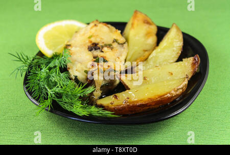 Still-life con la frittura di pesce e patate al forno su un piatto Foto Stock