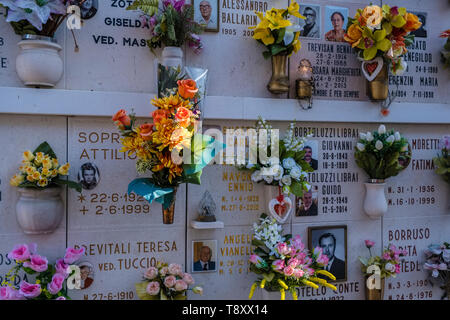 Urna tombe decorate con fiori colorati presso il cimitero Isola Cimitero di San Michele Foto Stock