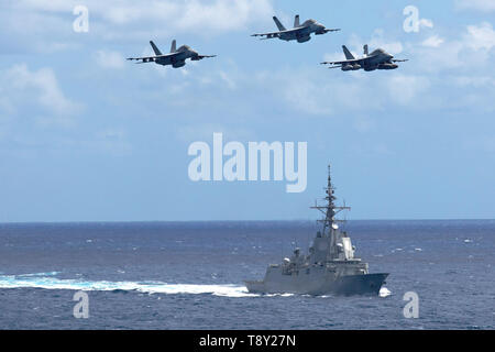 Tre Stati Uniti Navy F/A-18F Super Hornet fighter aircraft volare oltre la marina spagnola Alvaro de Bazan-class frigate ESP Mendez Nuñez durante le operazioni congiunte con la Nimitz-class portaerei USS Abraham Lincoln Carrier Strike gruppo Maggio 7, 2019 nel Mar Ionio. Foto Stock