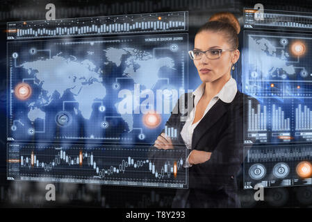 Young Lady funziona con virtual interfaccia grafica in ufficio futuristico Foto Stock