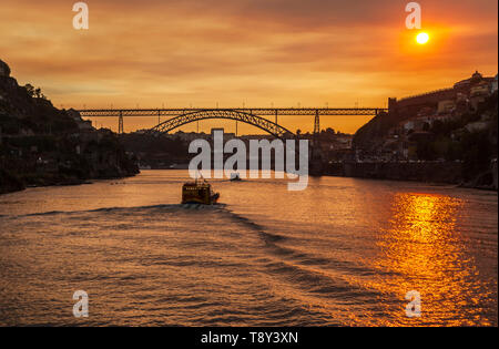 Impostazione di Sun al di sopra di Dom Luís I Bridge, Porto, Portogallo Foto Stock