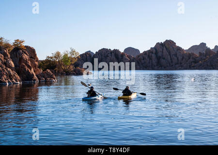 Un uomo e una donna kayak su la mattina presto sul lago Watson sotto i cieli blu in Prescott, Arizona, Stati Uniti d'America Foto Stock