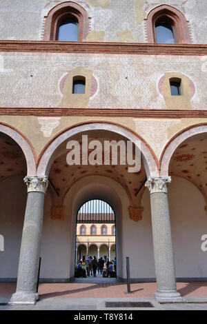 Vista dalla corte interna alle mura, ingresso, colonne e arcate di antica fortezza medievale Rocchetta all'interno del Castello Sforzesco di Milano. Foto Stock