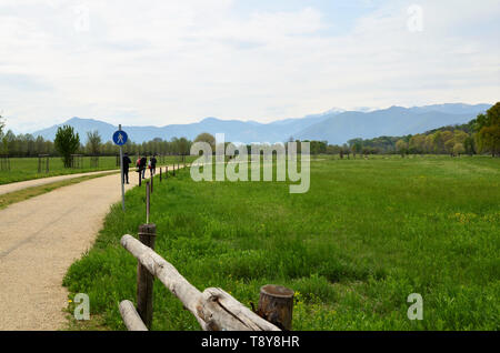 Venaria, Piemonte, Italia. Aprile 2019. Il percorso si snoda attraverso il parco tra prati e alberi. La gente passeggia e godetevi il relax nella natura. Foto Stock