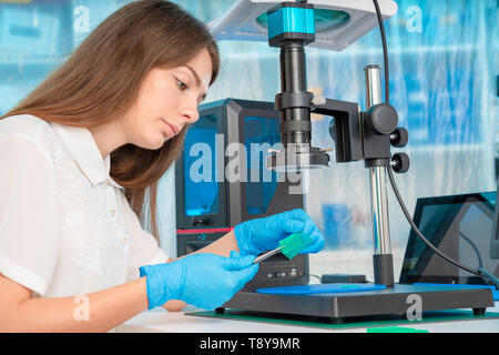 Lavoratore di sesso femminile nel controllo di resina LCD / DLP / SLA stampante 3D nel laboratorio di tecnologia Foto Stock