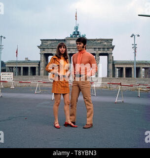 Das Musikerpaar israelische Esther & Abi Ofarim posiert in orangener Kleidung vor dem Brandenburger Tor; Deutschland 1967. Il musicista israeliano giovane Esther & Abi Ofarim in posa di vestiti arancioni davanti alla Porta di Brandeburgo; Germania 1967. Foto Stock