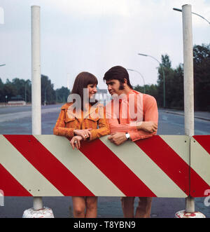 Das Musikerpaar israelische Esther & Abi Ofarim posiert in orangener Kleidung vor dem Brandenburger Tor; Deutschland 1967. Il musicista israeliano giovane Esther & Abi Ofarim in posa di vestiti arancioni davanti alla Porta di Brandeburgo; Germania 1967. Foto Stock