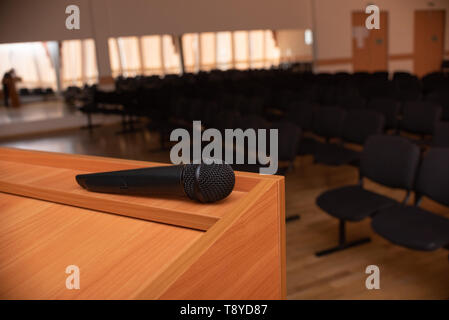 Microfono sul tribune nella parte anteriore della sala riunioni sedie vuote Foto Stock