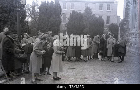 Degli anni Cinquanta, storico, ospiti di nozze in piedi al di fuori di una chiesa in attesa di vedere il recentemente sposato giovane venuto fuori, Inghilterra, Regno Unito. Foto Stock