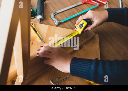 Gruppo donna mobili in legno,il fissaggio o la riparazione di casa con le misure lineari a nastro.la vita moderna concetti idee Foto Stock