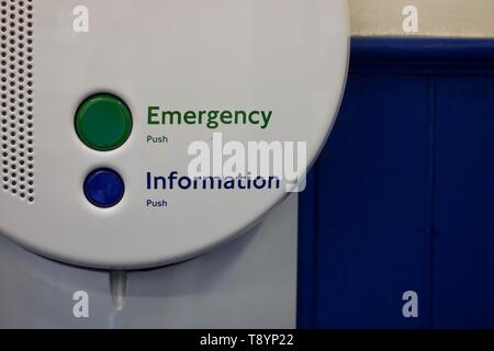 Verde pulsante di emergenza e il pulsante blu delle informazioni sul round pannello bianco con altoparlante contro sfondo blu Foto Stock