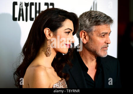 Amal Clooney (sinistra) e George Clooney frequentando il Catch-22 UK Premiere, tenutasi al cinema Vue Westfield di Londra. Foto Stock