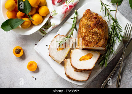 Rotolo di carne (involtino) con ripieno di albicocca e spezie su una luce di pietra o di sfondo di ardesia. La Giornata del ringraziamento antipasto. Vista superiore piatta backgrou laici Foto Stock