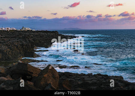 Costa rocciosa di Playa Blanca in Lanzarote durante le luci della sera Foto Stock