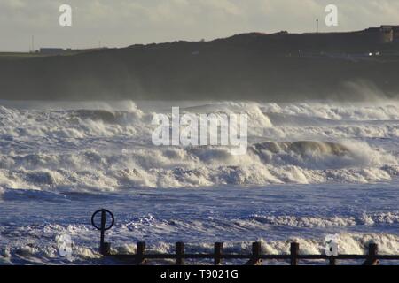 Ruvida di rottura onde sulla spiaggia di Aberdeen durante una tempesta di neve. La Scozia, Regno Unito. Foto Stock