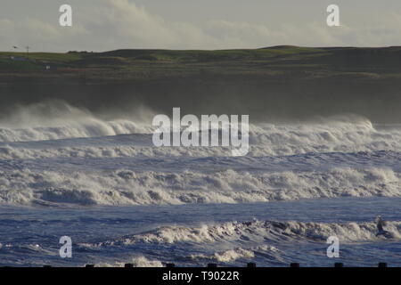 Ruvida di rottura onde sulla spiaggia di Aberdeen durante una tempesta di neve. La Scozia, Regno Unito. Foto Stock