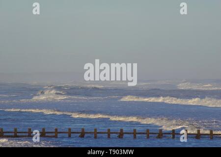 Ruvida di rottura onde sulla spiaggia di Aberdeen durante una tempesta di neve. La Scozia, Regno Unito. Foto Stock