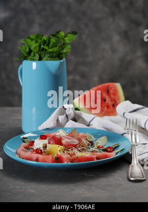 Piastra con una deliziosa insalata di anguria su tavola Foto Stock