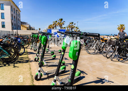 Valencia, Spagna - 12 Maggio 2019: biciclette a noleggio per i turisti e gli scooter elettrici da calce parcheggiato sulla spiaggia di Valencia. Foto Stock
